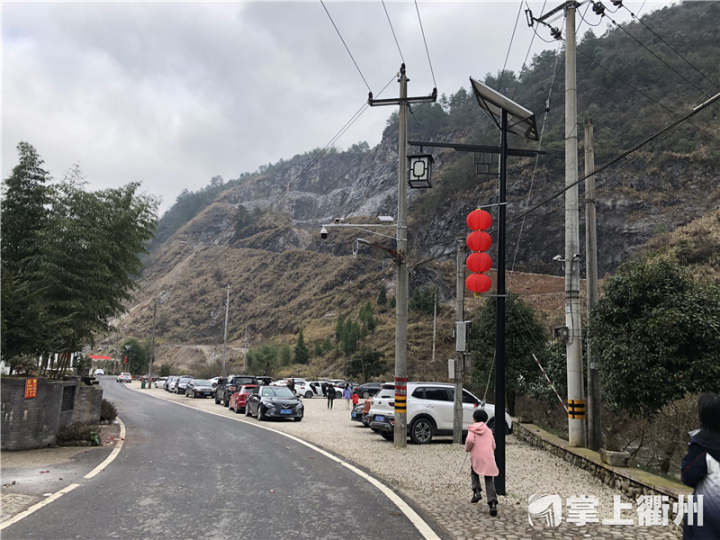 正月初一,衢江区灰坪乡白塔新村道路两旁红红灯笼高高挂起,村口停车场