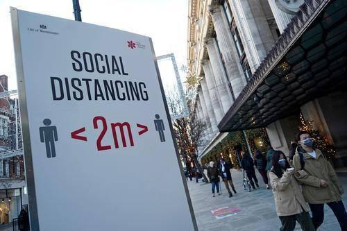12月20日，英国伦敦牛津街上提醒人们保持社交距离的标牌。图源：新华社