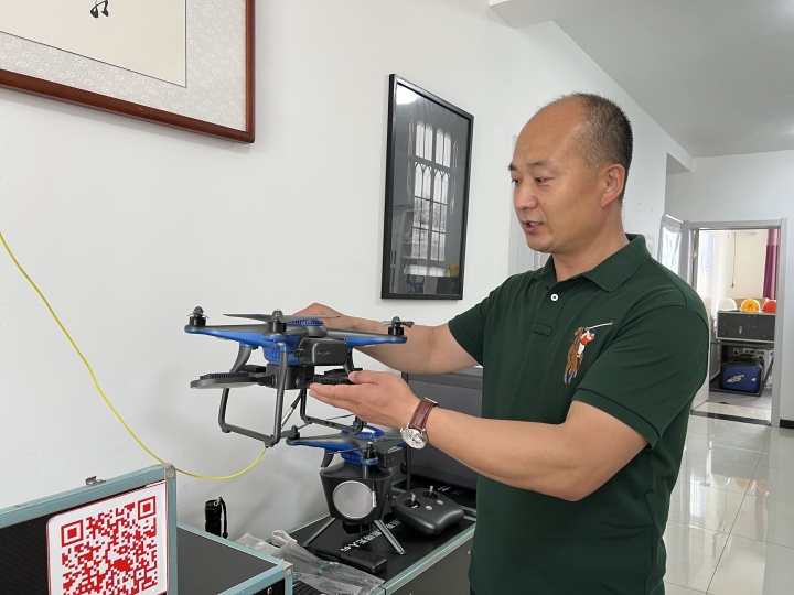 张永超向潮新闻记者介绍照明无人机设备。 叶怡霖 摄.jpg