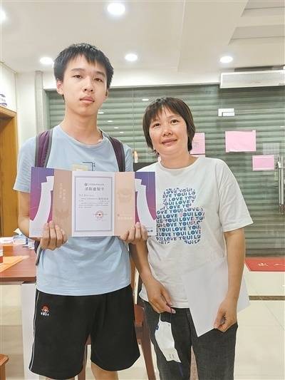中考641分的陈弘涛和妈妈展示录取通知书。
